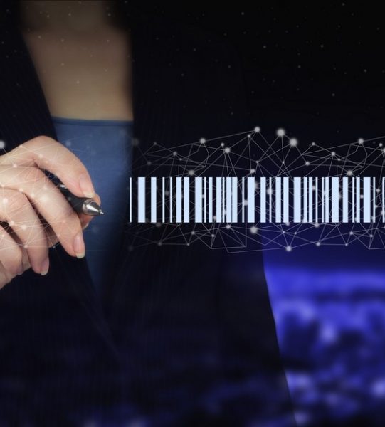 Bar Code Price Tag Merchandise Concept. Hand holding digital graphic pen and drawing digital hologram Bar Code Price Tag sign on city dark blurred background. Warehouse and logistics
