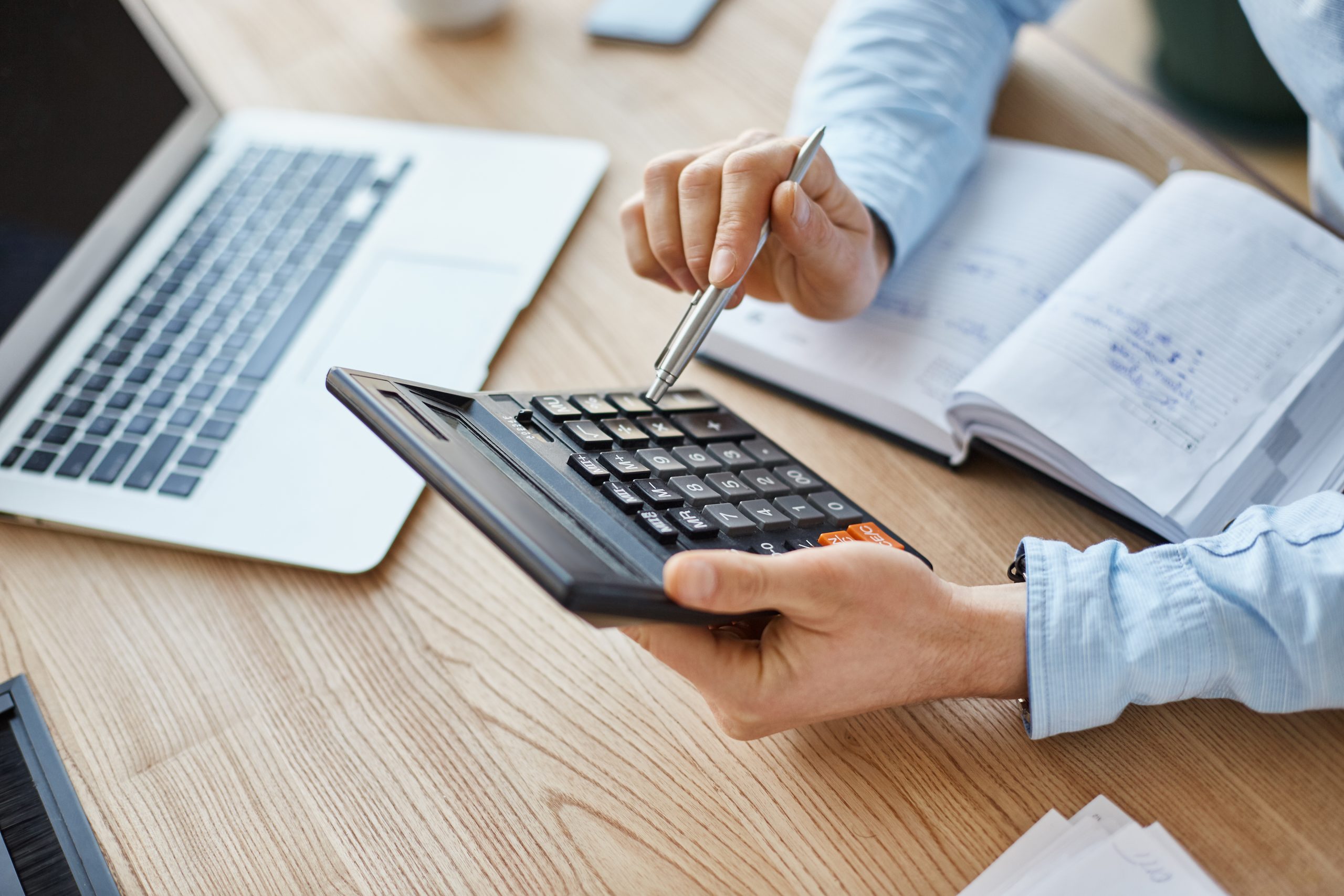 cropped view professional serious finance manager holding calculator hands checking company month s profits scaled