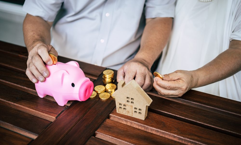 elderly couples talking about finance with piggy bank