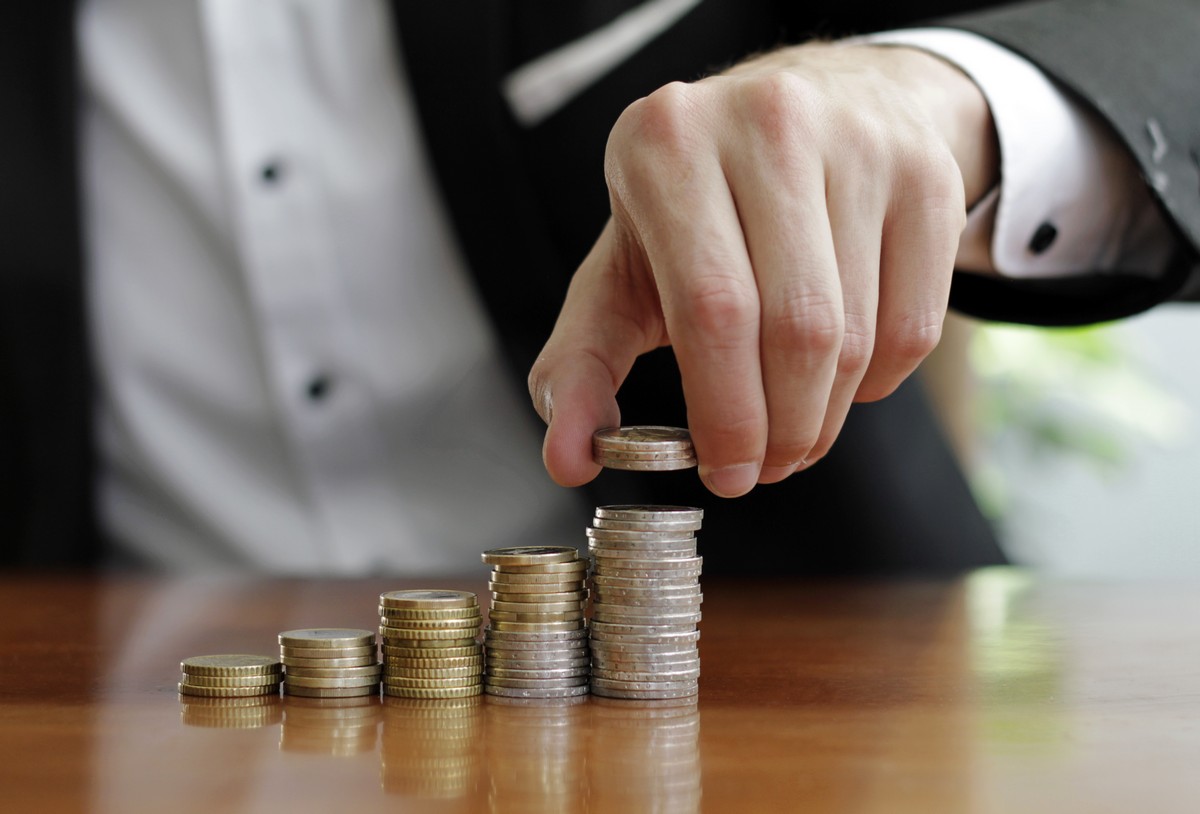 closeup shot businessman s hands counting stacks coins after business success